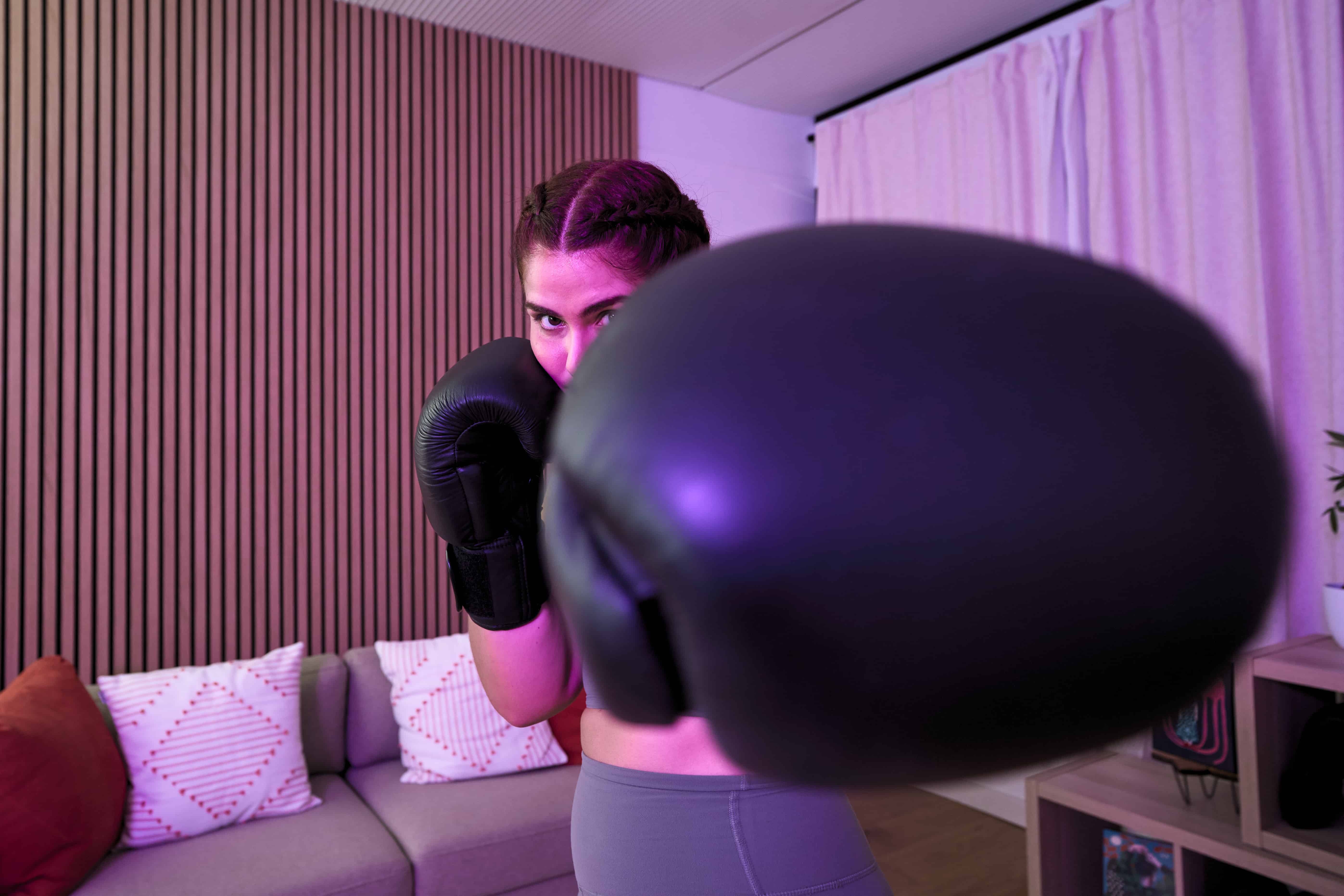 Woman showing boxing glove at home